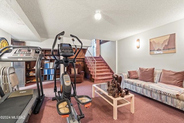 workout room featuring carpet and a textured ceiling