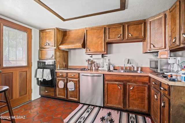 kitchen with a textured ceiling, appliances with stainless steel finishes, sink, and custom exhaust hood