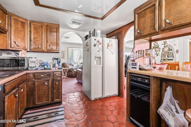 kitchen featuring a textured ceiling, stainless steel appliances, and dark tile patterned floors