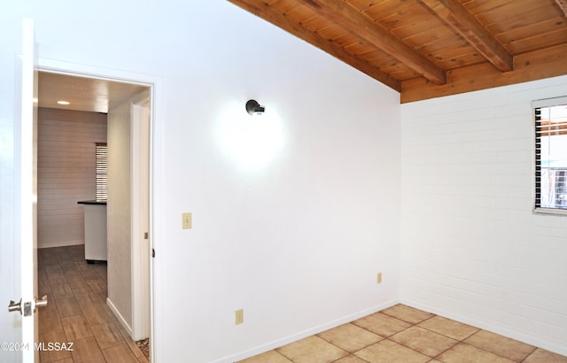 empty room with vaulted ceiling with beams, light hardwood / wood-style flooring, and wooden ceiling