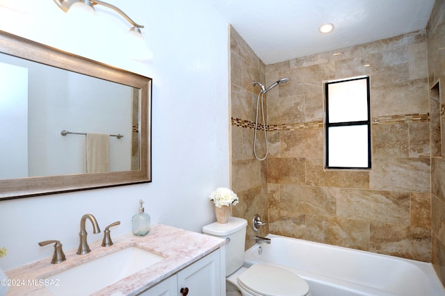 full bathroom with vanity, tiled shower / bath combo, and toilet