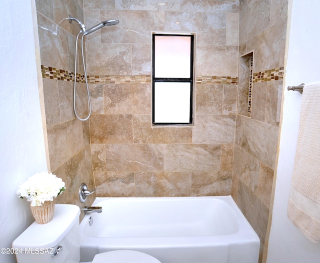 bathroom with toilet and tiled shower / bath combo