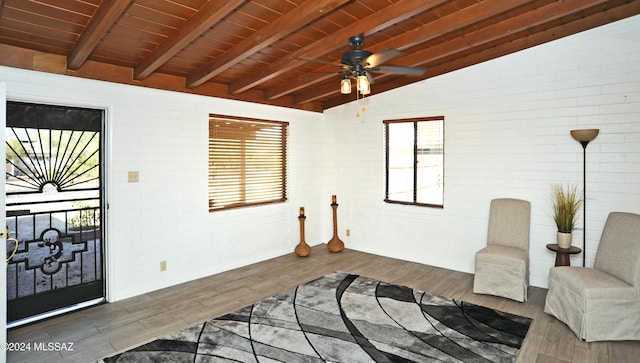 sitting room featuring brick wall, lofted ceiling with beams, dark hardwood / wood-style floors, and wooden ceiling