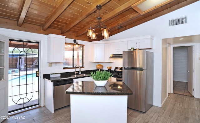 kitchen featuring appliances with stainless steel finishes, lofted ceiling with beams, a center island, wooden ceiling, and white cabinets