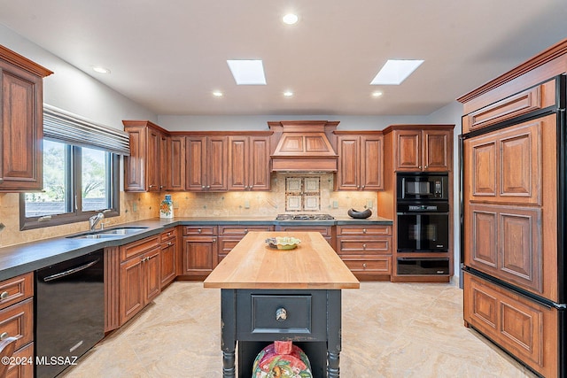 kitchen featuring a kitchen island, wood counters, sink, black appliances, and custom exhaust hood