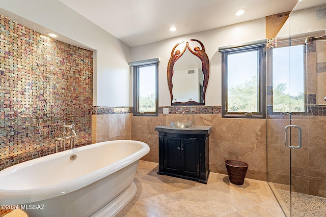 bathroom with vanity, tile walls, shower with separate bathtub, and tile patterned flooring