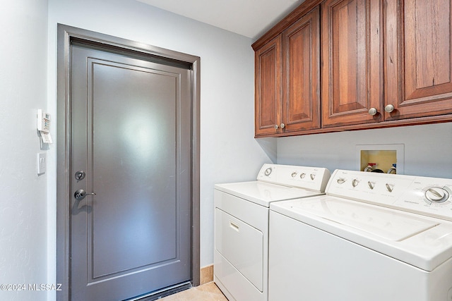 clothes washing area with light tile patterned flooring, independent washer and dryer, and cabinets