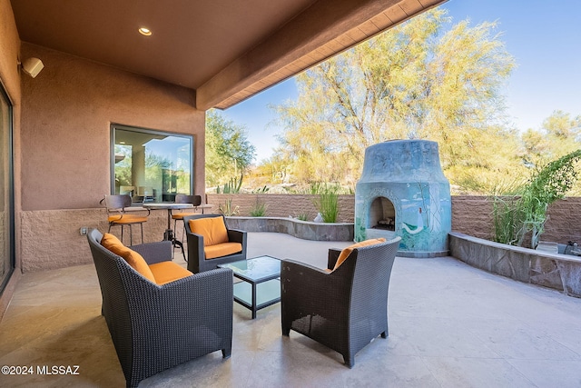 view of patio with an outdoor living space with a fireplace