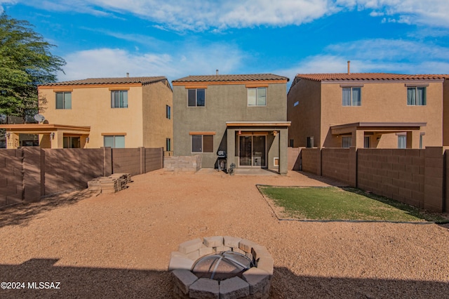 back of house featuring a patio area and a fire pit