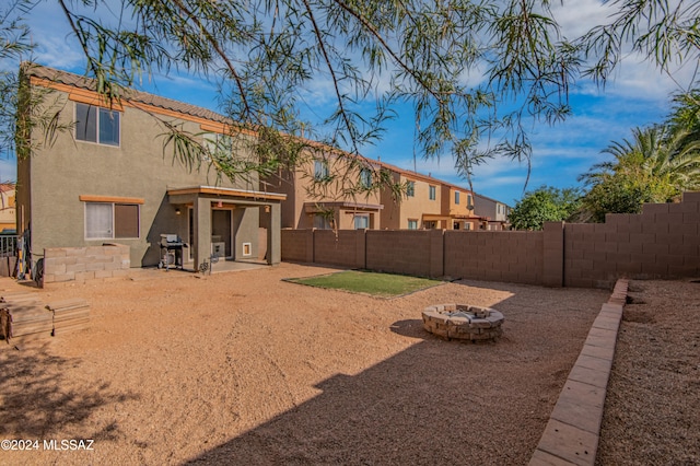 rear view of house with a patio area and an outdoor fire pit