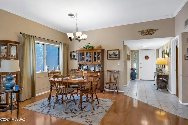 dining room featuring an inviting chandelier, light hardwood / wood-style flooring, and ornamental molding