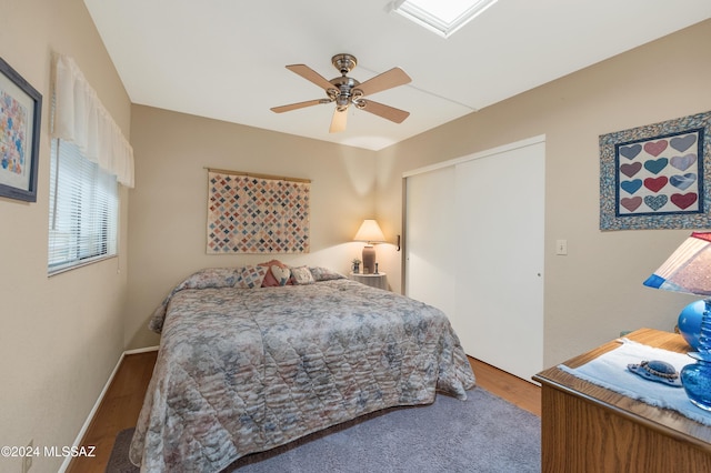 bedroom featuring a closet, ceiling fan, baseboards, and wood finished floors