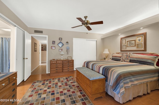 bedroom with ceiling fan, a closet, visible vents, and wood finished floors