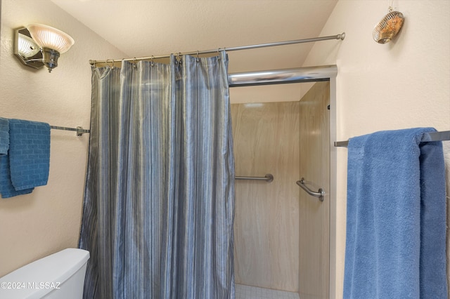 bathroom with a shower with curtain and toilet