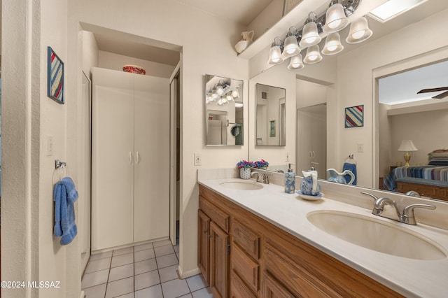 ensuite bathroom featuring connected bathroom, tile patterned flooring, a sink, and double vanity