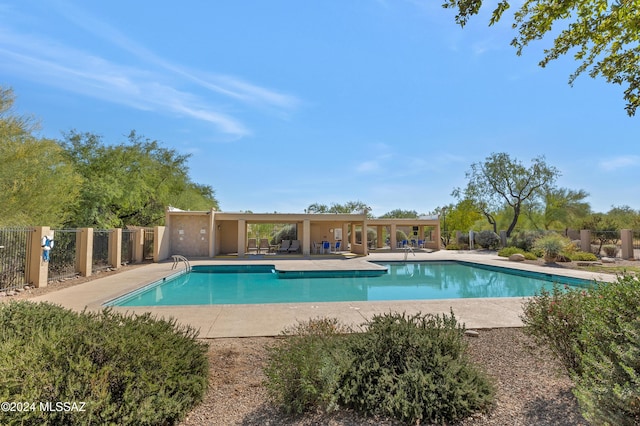 community pool featuring a patio and fence