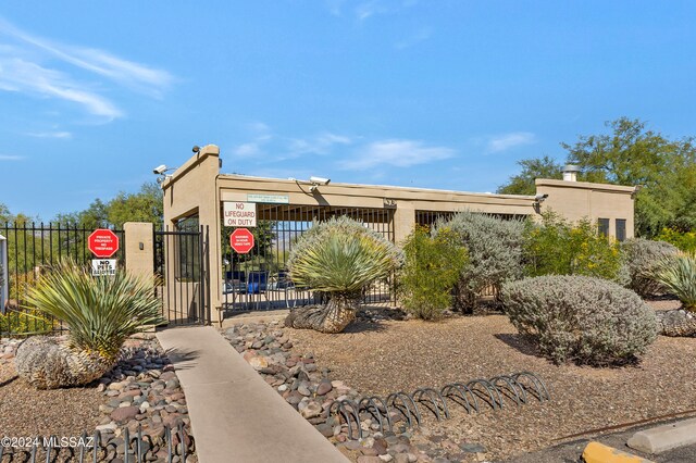 view of front facade with a gate, fence, and stucco siding