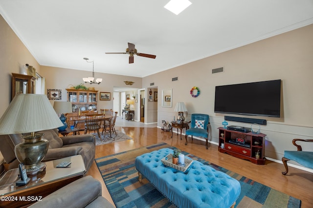 living room with ornamental molding, wainscoting, visible vents, and wood finished floors