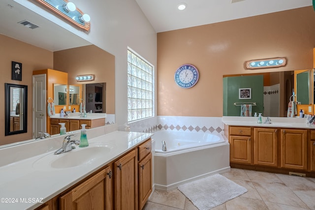 bathroom featuring vanity, a tub to relax in, tile patterned floors, and lofted ceiling