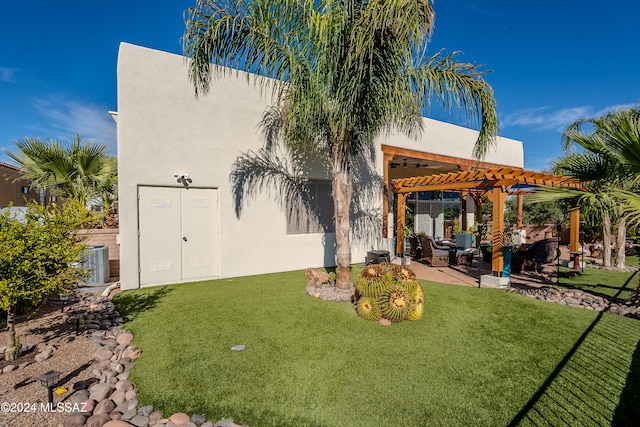 back of house with central air condition unit, a patio area, a lawn, and a pergola