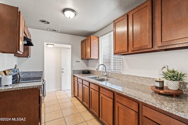 kitchen featuring electric range oven, light stone countertops, sink, and light tile patterned flooring