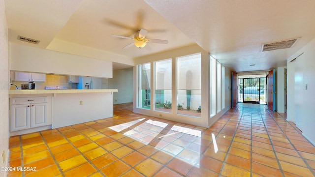 kitchen with tile countertops, white cabinets, light tile patterned flooring, and white refrigerator with ice dispenser