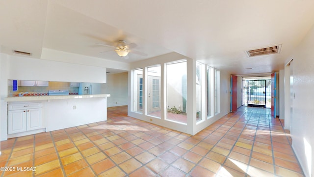 kitchen with white cabinetry, fridge with ice dispenser, visible vents, and light countertops