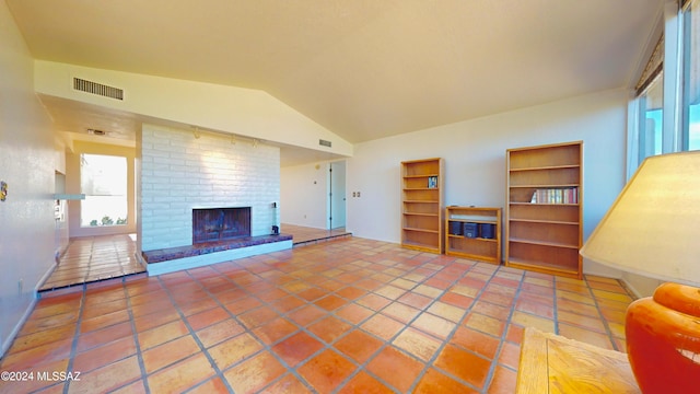 tiled living room with lofted ceiling and a brick fireplace