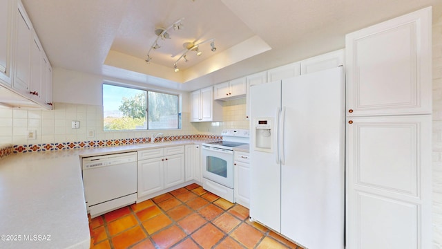 kitchen with white appliances, white cabinets, light countertops, tasteful backsplash, and a raised ceiling