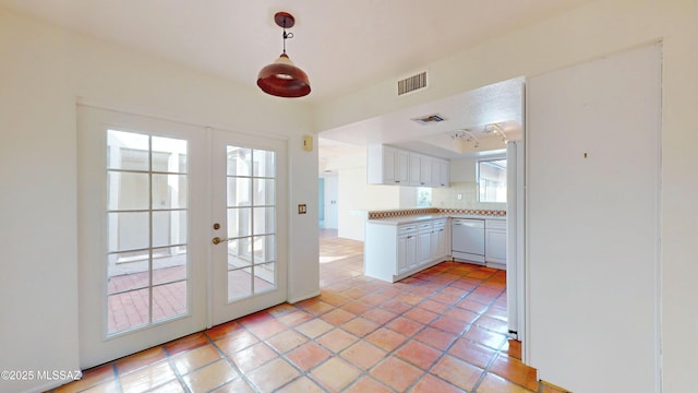 kitchen with light countertops, white cabinets, dishwasher, and visible vents