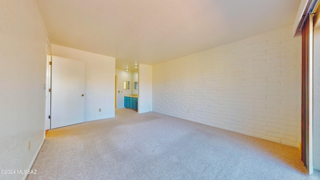 unfurnished bedroom featuring brick wall