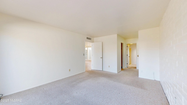 spare room featuring light carpet and visible vents