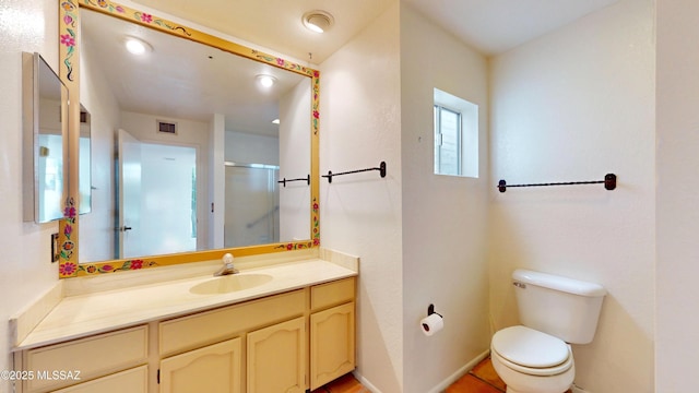 bathroom featuring visible vents, toilet, a shower stall, vanity, and baseboards