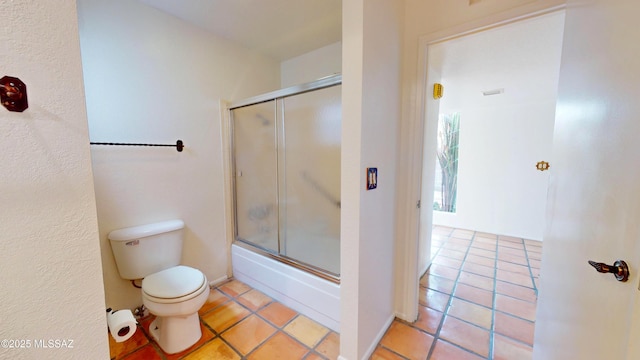 bathroom with toilet, enclosed tub / shower combo, and tile patterned floors