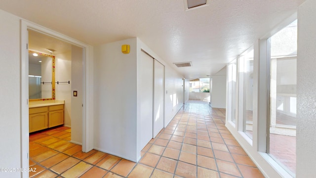 doorway featuring light tile patterned floors and a textured ceiling