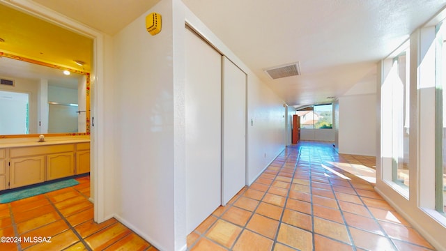 hall with sink and light tile patterned floors