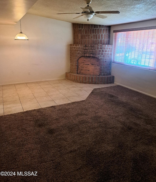 unfurnished living room featuring a fireplace, lofted ceiling, light tile patterned floors, ceiling fan, and a textured ceiling