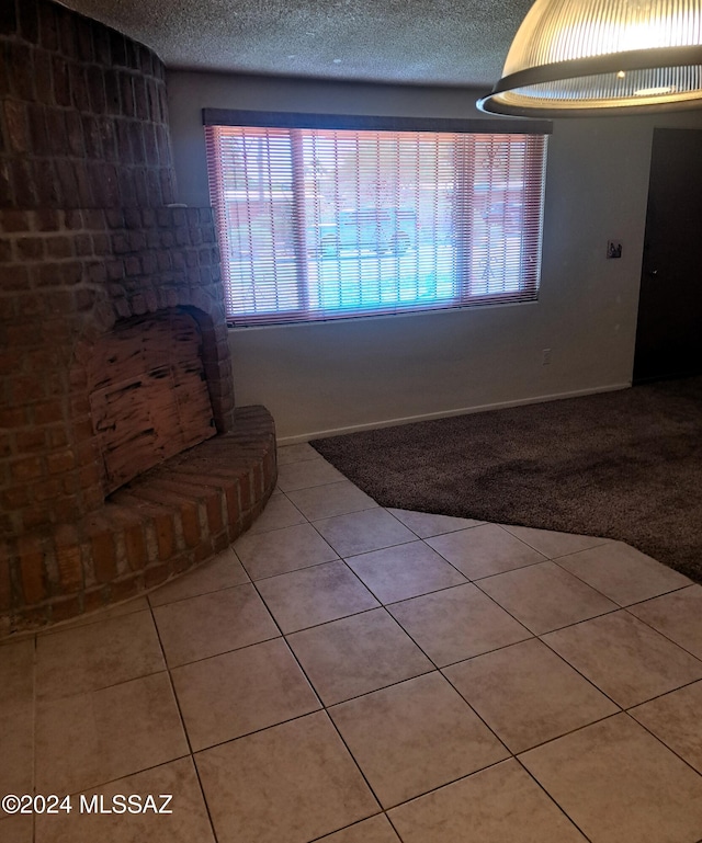 unfurnished living room with a textured ceiling and light tile patterned floors