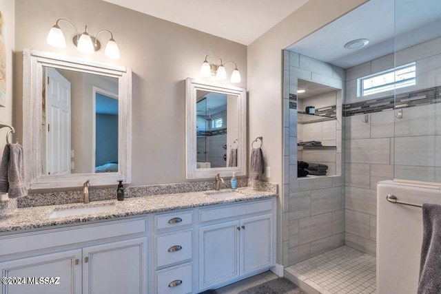 bathroom featuring vanity, tiled shower, and tile patterned flooring