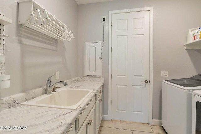 clothes washing area featuring sink, washer and clothes dryer, cabinets, and light tile patterned flooring