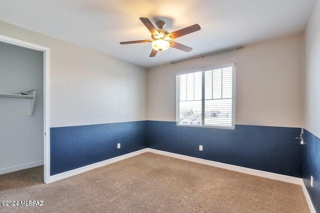 carpeted spare room with ceiling fan