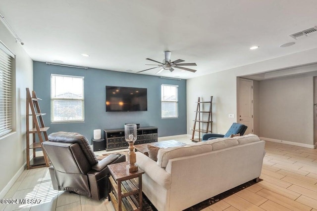 living room featuring ceiling fan, light hardwood / wood-style floors, and plenty of natural light