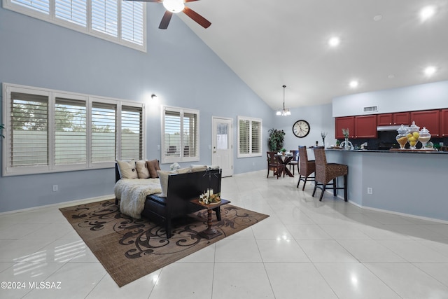 living room featuring ceiling fan with notable chandelier, high vaulted ceiling, and light tile patterned floors