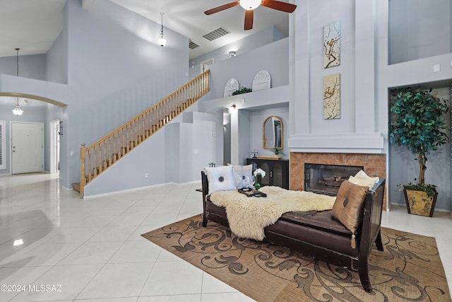 living room with light tile patterned flooring, high vaulted ceiling, a fireplace, and ceiling fan