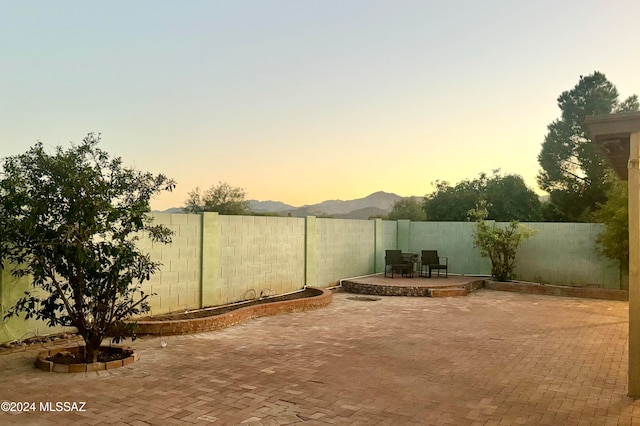 patio terrace at dusk featuring a mountain view