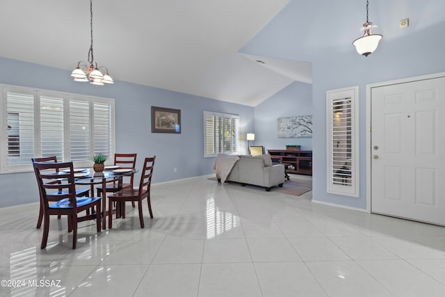 tiled dining room with a chandelier and high vaulted ceiling