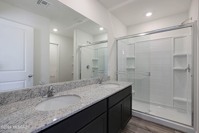 bathroom with vanity, a shower with door, and wood-type flooring