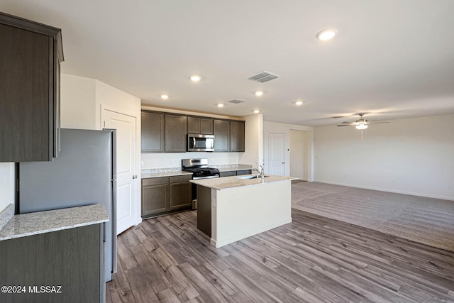 kitchen featuring stainless steel appliances, dark brown cabinetry, sink, ceiling fan, and wood-type flooring