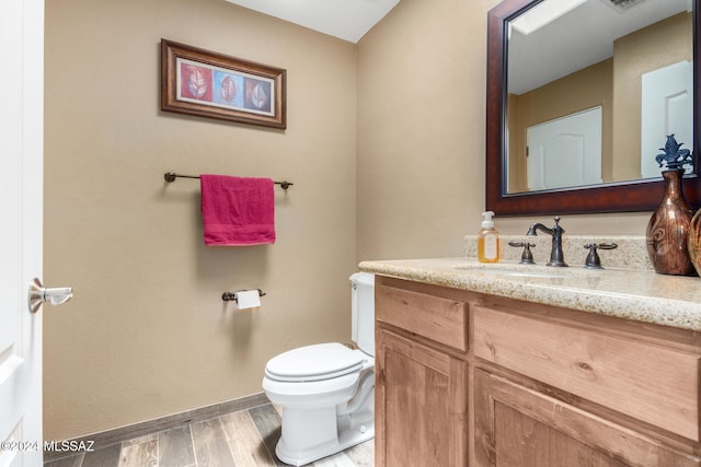 bathroom featuring hardwood / wood-style floors, vanity, and toilet