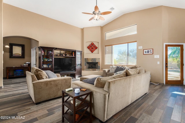 living room with a tile fireplace, lofted ceiling, ceiling fan, and dark hardwood / wood-style floors